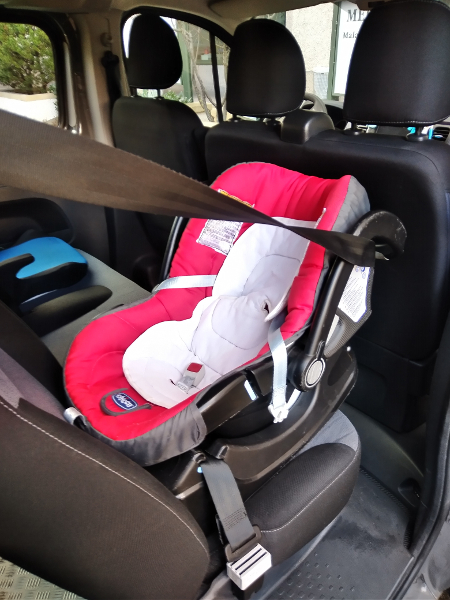 photo d'une coque bébé rouge attachée dans le minibus